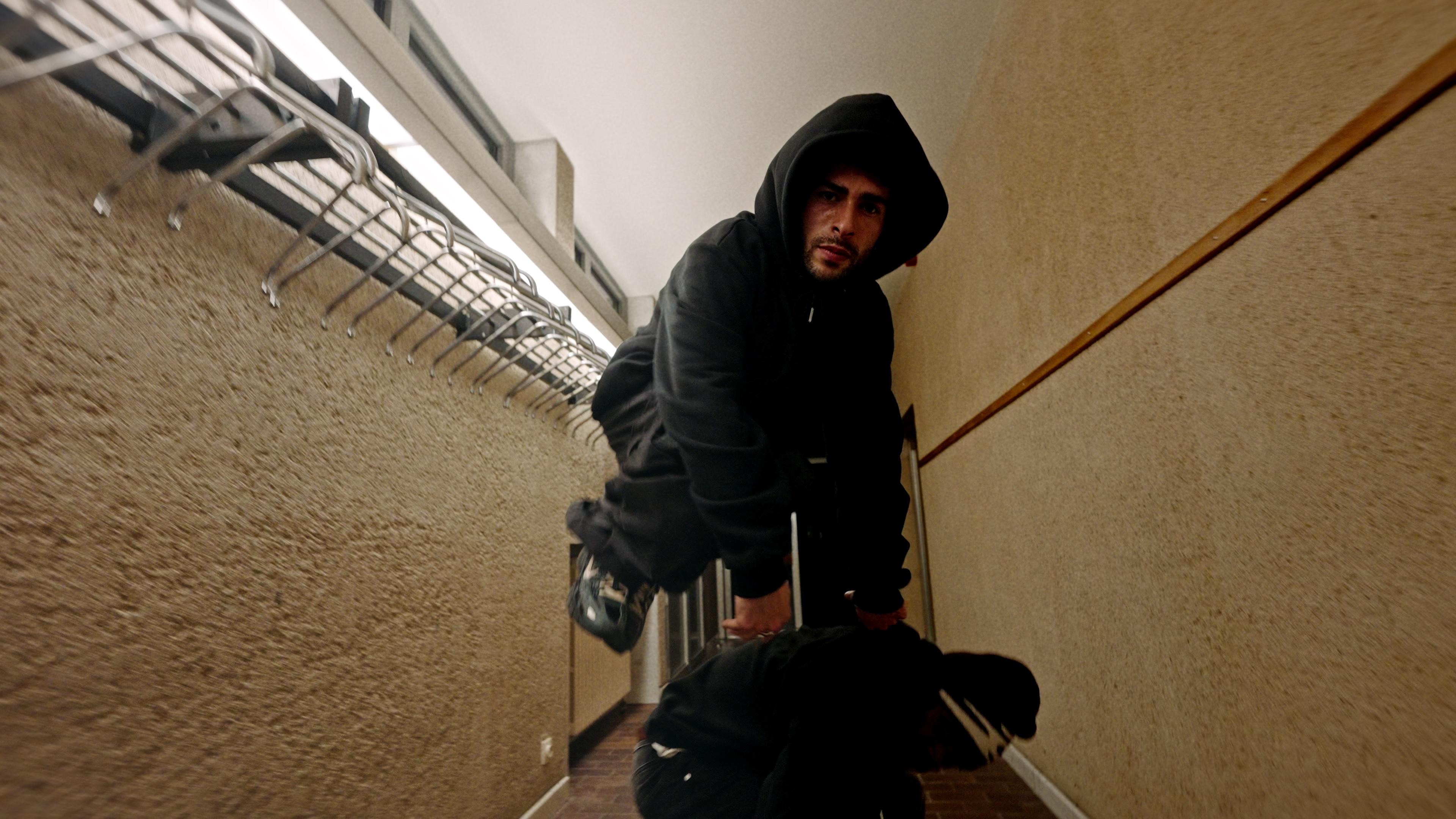 Two dancers leaning over the camera beside a staircase.