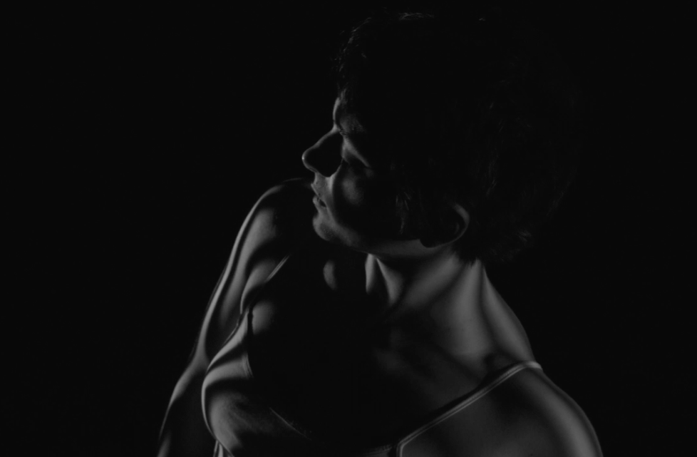 A dancer exploring the interaction between light and the body.